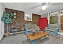 The sun room is furnished with comfortable seating, exposed brick, and lots of natural light at 200 Dogwood Dr, Canton, GA 30114
