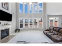 Bright, open living room with fireplace, high ceilings, large windows, and a leather sofa at 2430 Redbud Meadow Ln, Douglasville, GA 30135