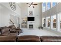 Spacious living room with high ceilings, fireplace, large windows, and comfortable leather seating at 2430 Redbud Meadow Ln, Douglasville, GA 30135