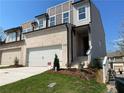 Contemporary townhome showing brick accents, a two-car garage, and a well-manicured lawn and walkway at 2335 Portrush Way (Lot 26) Dr, Atlanta, GA 30339