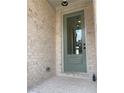 Close-up of a charming front door with glass panel, set in a brick entryway with modern outdoor lighting at 2335 Portrush Way (Lot 26) Dr, Atlanta, GA 30339