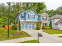 Inviting two-story home featuring a blend of brick and siding, a two-car garage, and landscaped front yard at 133 Parkway Dr, Fairburn, GA 30213