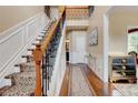 Elegant foyer featuring hardwood floors, a staircase with an ornate railing, and wainscoting at 133 Parkway Dr, Fairburn, GA 30213