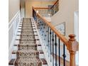 Elegant staircase features hardwood floors, decorative runner, and wrought iron railing at 133 Parkway Dr, Fairburn, GA 30213