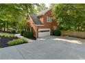 Brick home featuring a side-entry garage and a spacious driveway surrounded by mature landscaping at 2995 Aspen Ridge Ct, Snellville, GA 30078