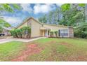 Traditional home with stone accents and a neat lawn, surrounded by mature trees at 6350 Mozart Dr, Riverdale, GA 30296
