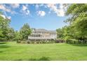 Expansive backyard with a multi-level deck, well-maintained lawn, and mature trees at 210 Little River Farms Trl, Canton, GA 30115