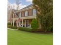 Charming brick home with a covered front porch, lush green lawn, and mature landscaping at 210 Little River Farms Trl, Canton, GA 30115