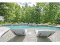 Close-up of the pool featuring submerged loungers, crystal-clear water, and a lush green backdrop at 210 Little River Farms Trl, Canton, GA 30115