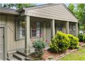 Inviting entrance to a charming home, featuring a covered porch, lush landscaping, and a warm, welcoming ambiance at 2343 Poplar Springs Ne Dr, Brookhaven, GA 30319