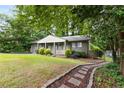 Charming home with a beautifully landscaped front yard and a stone pathway, nestled among mature trees at 2343 Poplar Springs Ne Dr, Brookhaven, GA 30319
