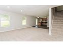Open-concept living space with plush carpet, natural light, and a view into the kitchen area at 2743 High Tide Dr, Atlanta, GA 30349