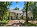 Charming two-story home with a light-colored exterior, well-maintained landscaping, and a winding stone walkway at 1260 Heards Ferry Rd, Sandy Springs, GA 30328