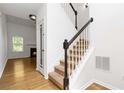 Bright entryway with hardwood floors, carpeted stairs, and view into the living room at 1620 Concord Meadows Dr, Smyrna, GA 30082