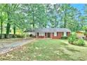Attractive single-story brick home featuring a covered carport and mature landscaping at 5868 Ash St, Forest Park, GA 30297