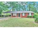 Cozy brick home with covered carport and lush front lawn at 5868 Ash St, Forest Park, GA 30297