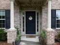 Inviting front porch with brick columns, decorative plants, and a 'Welcome Home' wreath at 5976 Rosie Se Ln, Mableton, GA 30126
