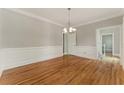 Traditional dining room boasting hardwood floors, elegant wainscoting, and a stylish chandelier at 1502 Lake Koinonia Dr, Woodstock, GA 30189