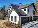 Stunning two-story home with a dark roof, light-colored siding and a three-car garage and driveway at 3785 Pilgrim Mill Rd, Cumming, GA 30041