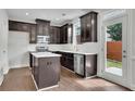 Well-lit kitchen with stainless steel appliances, island, dark cabinets, and a door to the backyard at 4965 Whiteoak Se Walk # 19, Smyrna, GA 30080