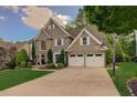 Inviting two-story home with a spacious driveway and well-maintained lawn surrounded by mature trees at 5028 Winding Hills Ln, Woodstock, GA 30189