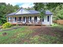 Inviting home with a classic front porch, lush greenery, and a well-kept lawn at 527 Cass White Nw Rd, Cartersville, GA 30121