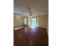 This living room is a spacious area offering access to an outdoor balcony, hardwood floors and a ceiling fan at 1202 Santa Fe Pkwy, Atlanta, GA 30350