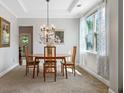 Formal dining room featuring a modern chandelier, tray ceiling and a view to the backyard at 1925 Piedmont Cove Ln, Cumming, GA 30040