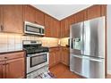 Modern kitchen features stainless steel appliances, wood cabinets, granite countertops at 1925 Piedmont Cove Ln, Cumming, GA 30040