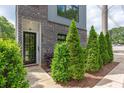 Modern home entrance, showcasing verdant landscaping and a stylish glass panel front door at 417 E College Ave # 102, Decatur, GA 30030