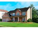 Lovely two-story home with brick facade, manicured lawn and shrubbery at 5281 Tormeall Trce, Suwanee, GA 30024