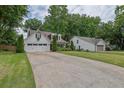 Spacious one-story home with white siding, attached garage, long driveway, and a well-maintained lawn at 115 Ocee View Ct, Alpharetta, GA 30022