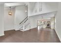 Open-concept living room with hardwood floors, a staircase, high ceilings, and modern light fixtures at 115 Ocee View Ct, Alpharetta, GA 30022