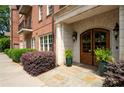 Apartment building entrance with detailed stonework, landscaping, and a beautiful arched wooden door at 351 Washington Ne Ave # 205, Marietta, GA 30060