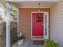 A bright red door with a decorative wreath is surrounded by brickwork and lush greenery creating an inviting entrance at 3700 Mays Xing, Atlanta, GA 30331