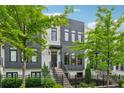 Contemporary two-story townhome featuring a dark-trimmed facade, landscaped yard, and steps to the front door at 1106 Briar Cove Cir, Atlanta, GA 30329