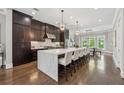 Spacious kitchen with a large marble island, pendant lighting, and dark wood cabinetry at 1106 Briar Cove Cir, Atlanta, GA 30329