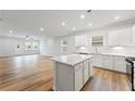 Open-concept kitchen with white cabinetry, stainless appliances, and a spacious center island at 401 Village Ln, Fairburn, GA 30213