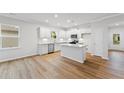 Spacious kitchen with white cabinetry, island, stainless appliances, and hardwood floors at 401 Village Ln, Fairburn, GA 30213