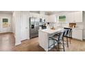 Modern kitchen features stainless steel appliances, white cabinets, quartz counters, and center island with seating at 401 Village Ln, Fairburn, GA 30213