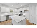 Well-lit kitchen with white cabinets, quartz countertop, and stainless steel appliances at 401 Village Ln, Fairburn, GA 30213
