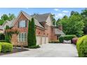 Spacious driveway leading to a three-car garage with a brick exterior and well-maintained landscaping at 5025 Savannah Run, Cumming, GA 30040
