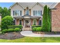 Charming home with a well-maintained lawn, lush green bushes, and a paved walkway leading to the entrance at 5025 Savannah Run, Cumming, GA 30040