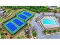 Aerial view showcasing community tennis courts, a swimming pool, and manicured green spaces at 1147 Halletts Peak Pl, Lawrenceville, GA 30044