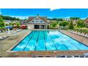 A beautiful community swimming pool awaits with plenty of chairs and umbrellas at 1147 Halletts Peak Pl, Lawrenceville, GA 30044