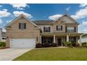 Charming two-story brick home with a manicured lawn, covered porch, and two car garage at 4832 Stone Way Path, Buford, GA 30519