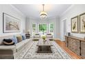 Comfortable living room features a large sofa, stylish rug, and bay windows overlooking the front yard at 763 Old Paper Mill Se Dr, Marietta, GA 30067