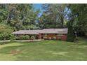 Charming one-story brick home with lush green lawn and mature trees offering great curb appeal at 112 Pioneer Trail, Cartersville, GA 30121