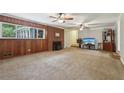 Spacious living room features a wood-burning fireplace, wood paneling, and large windows at 112 Pioneer Trail, Cartersville, GA 30121