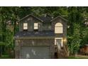 Charming two-story home features a brick facade, arched window, and a two-car garage nestled among mature trees at 2766 Stonecreek Se Rd, Smyrna, GA 30080